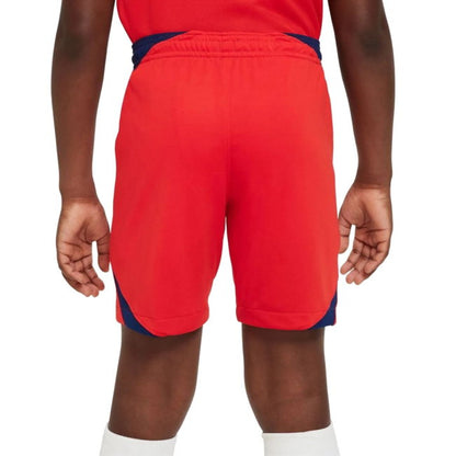 A child wearing bright red athletic shorts with navy blue side panels and a navy waistband, shown from the back against a plain white background.