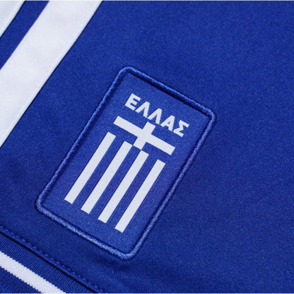 Close-up of a blue sports jersey with a white emblem featuring Greek letters and cross.