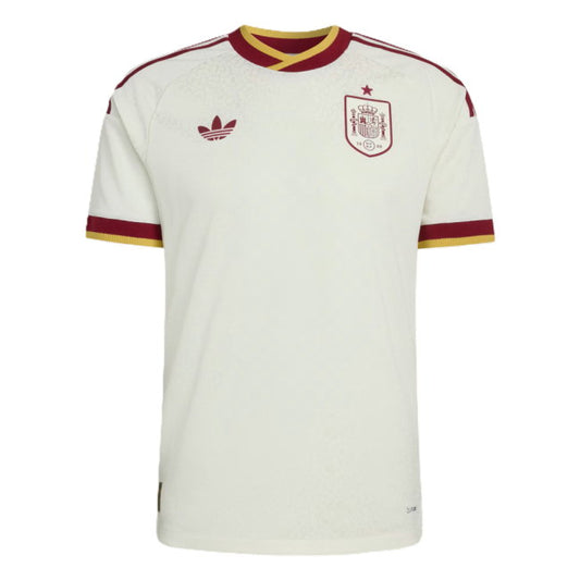 White Spain national football team home jersey by Adidas, featuring maroon and gold trim on the collar and sleeve cuffs, with the Adidas trefoil logo and Spain crest on the chest.