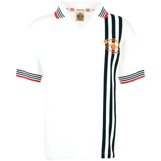 A white vintage Manchester United football shirt with three black stripes down the right side, black and red striped trim on the collar and sleeves, and the Manchester United crest on the left chest.