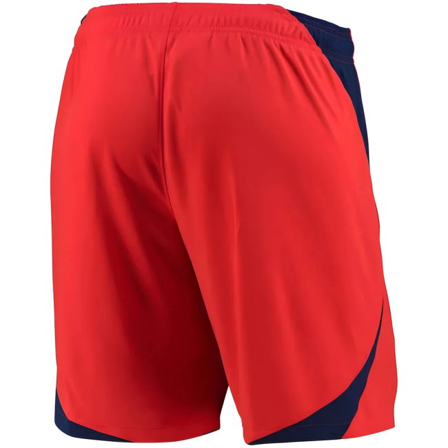 Red athletic shorts with navy blue side panels and a matching navy hem, shown from the back on a white background.