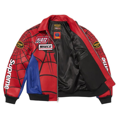 A Supreme x Spider-Man themed bomber jacket featuring red and black web-patterned faux leather panels, a blue color-blocked side panel, and sponsor patches including Klutz, Wiseco, and Versace.