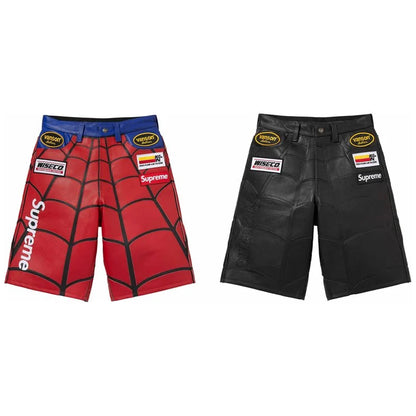 Two Supreme x Minerva MMA shorts shown side by side on a white background: one red and blue with a black spiderweb pattern and white Supreme logo, and one black with a textured leather-like finish and black Supreme logo.