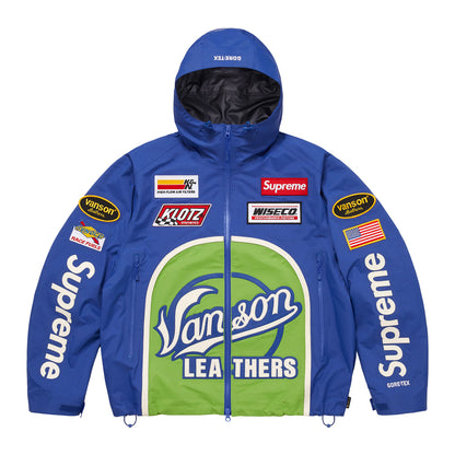 A blue hooded jacket with a large green and white Vanson Leathers logo on the front, featuring multiple brand patches including Supreme, Vanson, Koz, and Wiseco on the chest and sleeves.